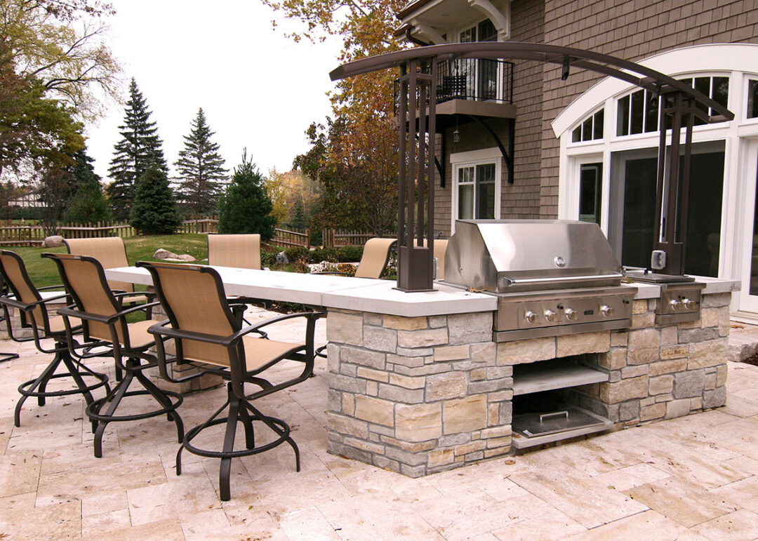 Large-outdoor-kitchen-with-seating-and-metal-arbor-for-lighting-in-edina-mn