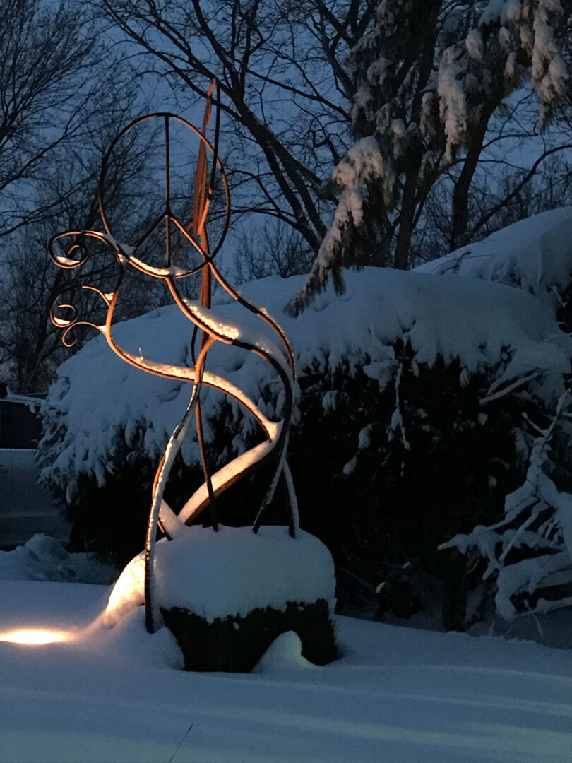 Metal-Sculpture-with-an-uplight-at-night-showcasing-it-in-Prior-Lake-Minnesota